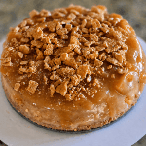 Caramel cake topped with crumbled biscuit pieces.