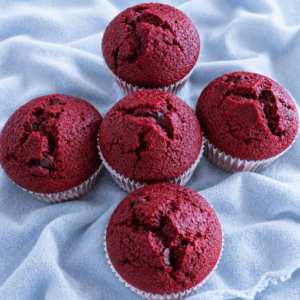 Red velvet muffins on a blue cloth.