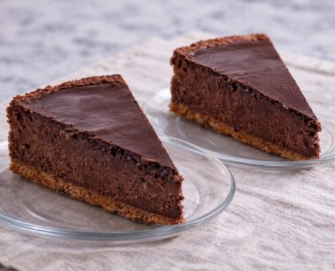 Two chocolate cheesecake slices on glass plates